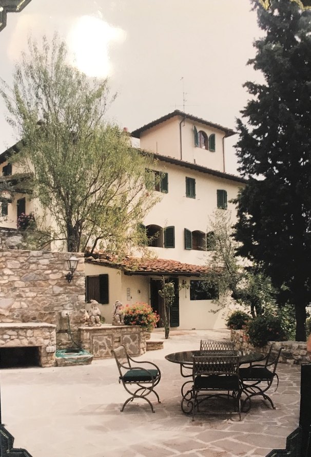 The courtyard of Villa Giaggioli, with a stone table and chairs and the colombaia tower rising above the house.